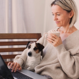 woman sitting with dog, sipping coffee